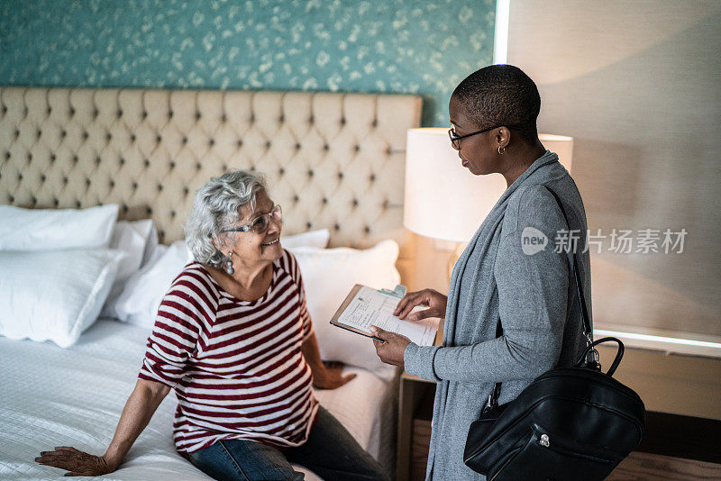 医生在卧室里和一位年长的女性聊天