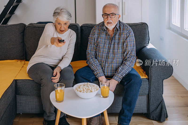 在家里看电视的老年夫妇