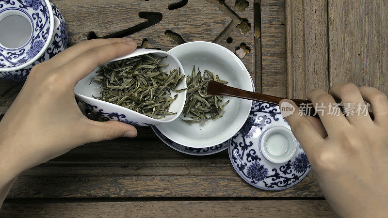 用漏斗把一个棕色的茶壶装满。瓷杯，钢勺。红茶、青茶、普洱茶、乌龙茶、铁观音、参茶、茶