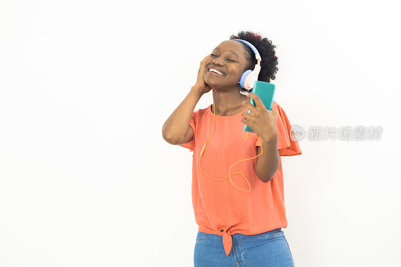 一个年轻的非洲女人的肖像享受她最喜欢的音乐在线