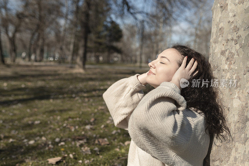 一个年轻女子的肖像享受太阳温暖她的脸