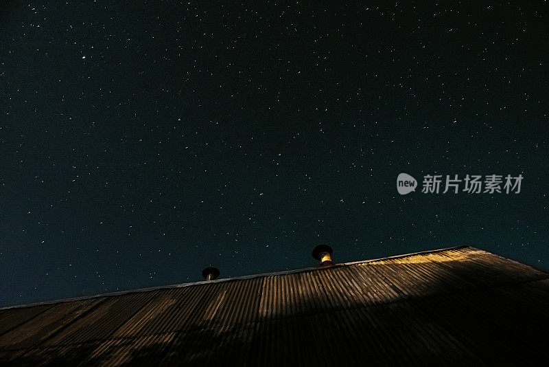 月光下的屋顶和上面的星空的照片。明星、屋顶、梦想。星空的大气摄影。在屋顶上散步，欣赏星星。软焦点