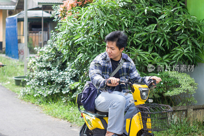 在居民区骑电动自行车的年轻人