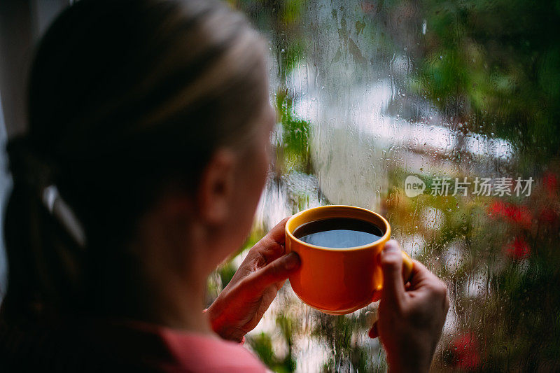 雨天在窗前喝咖啡的女人