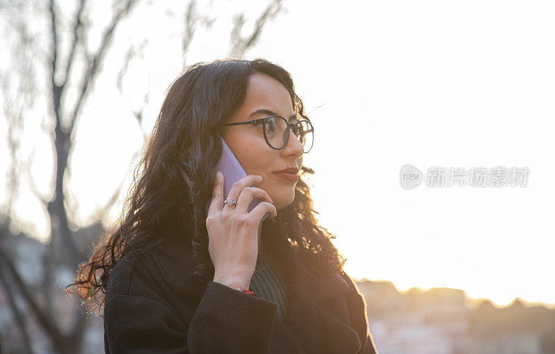 年轻漂亮的深色头发，戴眼镜的女人打电话