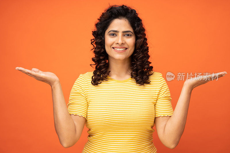 女孩快乐的肖像抱着两个手掌复制空间上橙色背景的股票照片