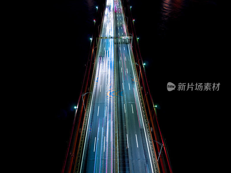 夜间里斯本主桥上的空中无人机天空视图镜头，有彩色的光迹