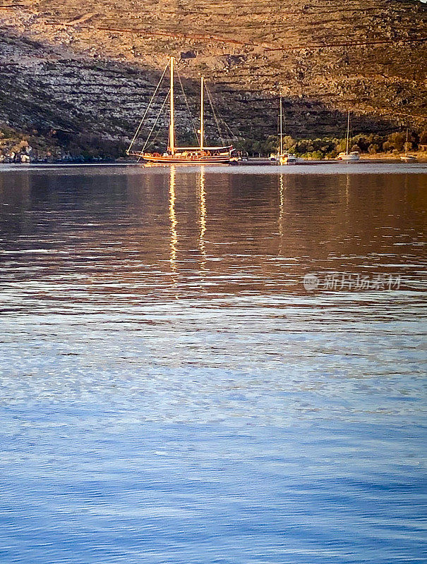 日落时海上的木制游艇