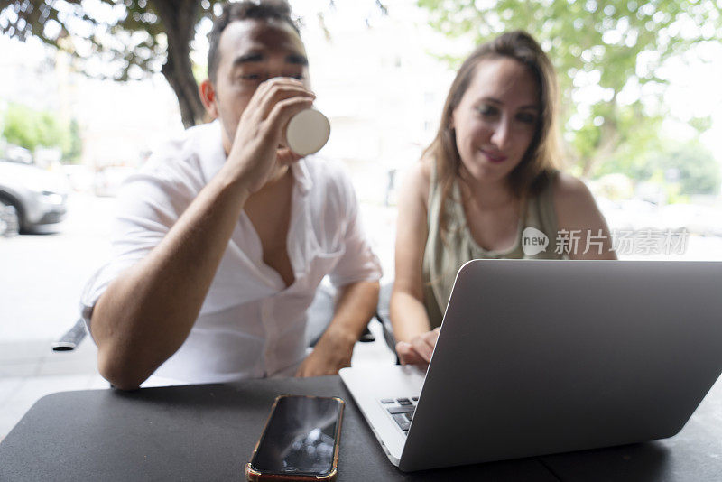 幸福的情侣坐在咖啡馆里用笔记本电脑上网