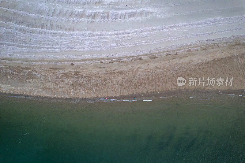 垂直鸟瞰干净的白色海滩和深蓝色的海水