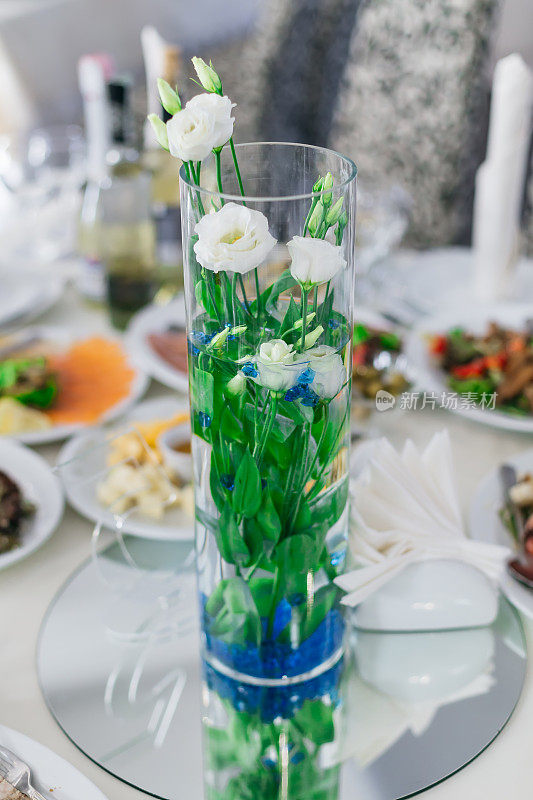 漂亮的透明花瓶，桌子上有许多玫瑰花