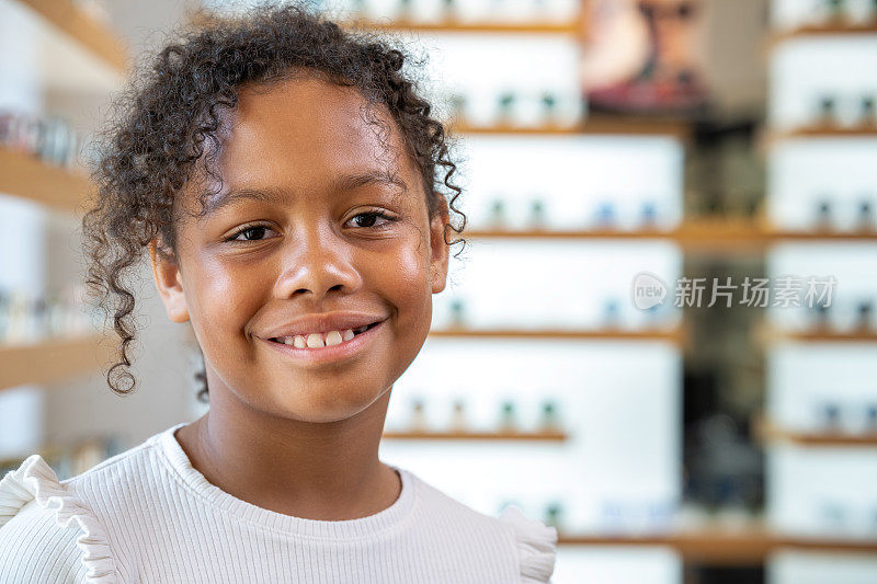 在眼镜店快乐微笑的黑人女孩的肖像