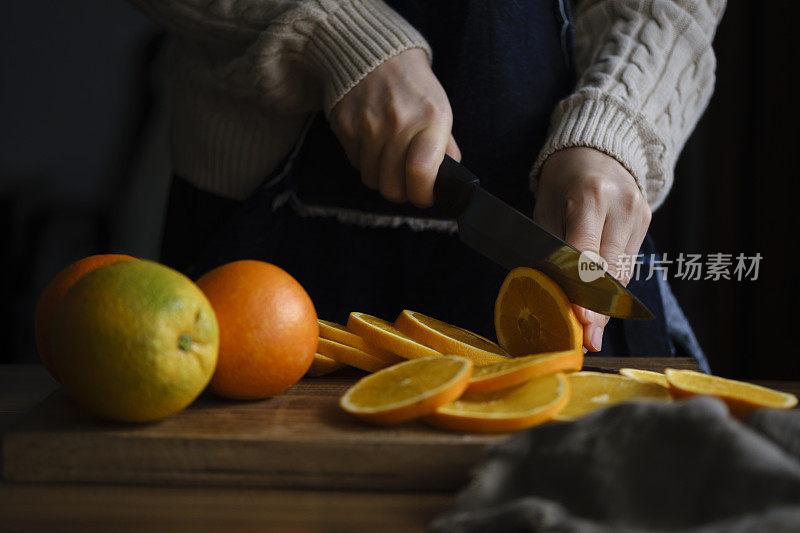 一个女人在木板上切橙子的特写镜头