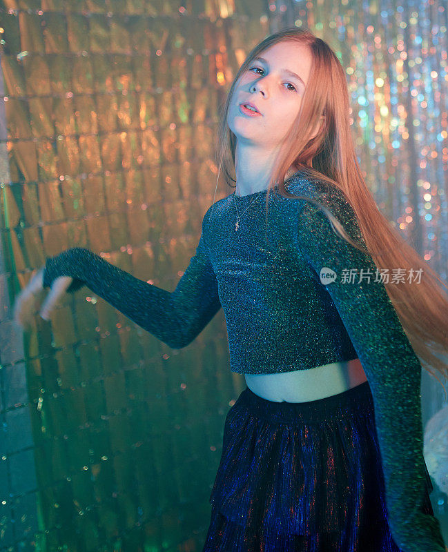 一头长发的可爱的青春期前女孩在新年晚会上蹦蹦跳跳