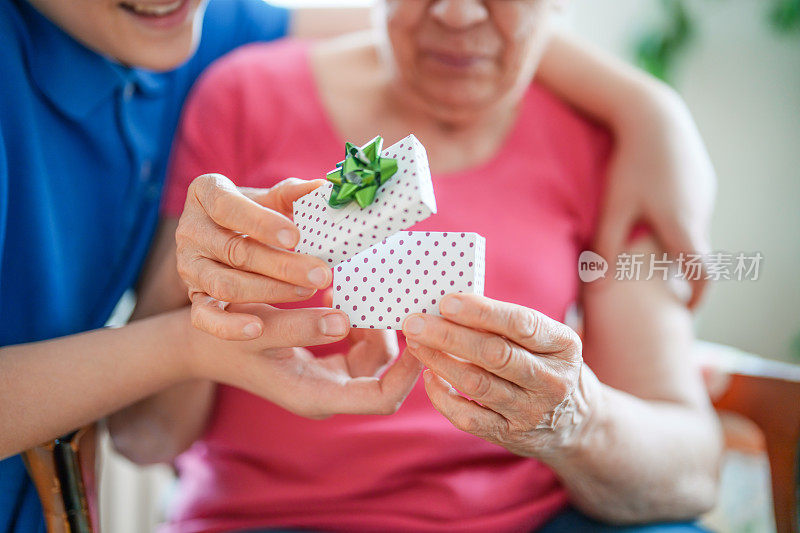 老妇人收到孙子送的礼盒。