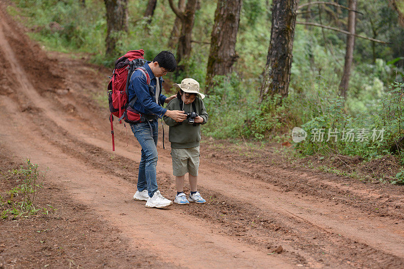 快乐的旅行者兄弟和女孩走在林间小路和山边。