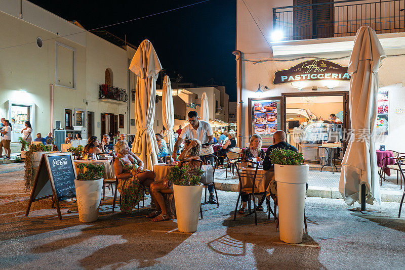 晚上，人们在圣维多洛卡波的路边咖啡馆里