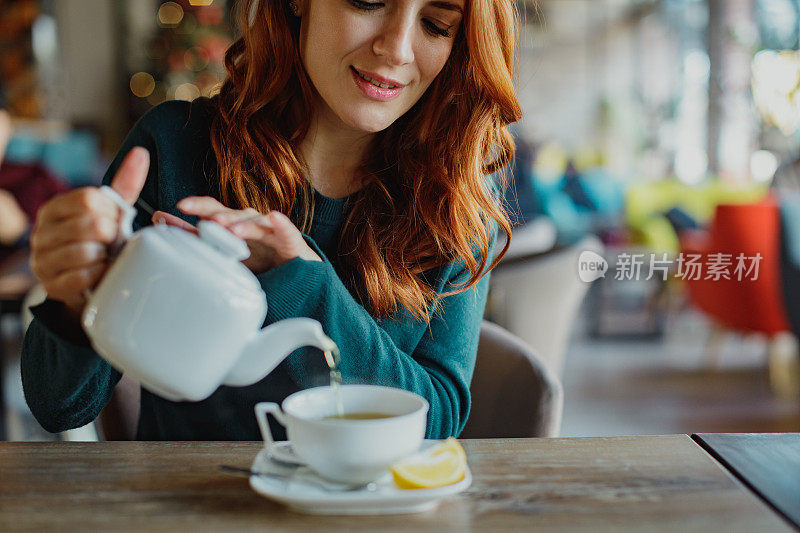 年轻女子把茶倒进杯子里