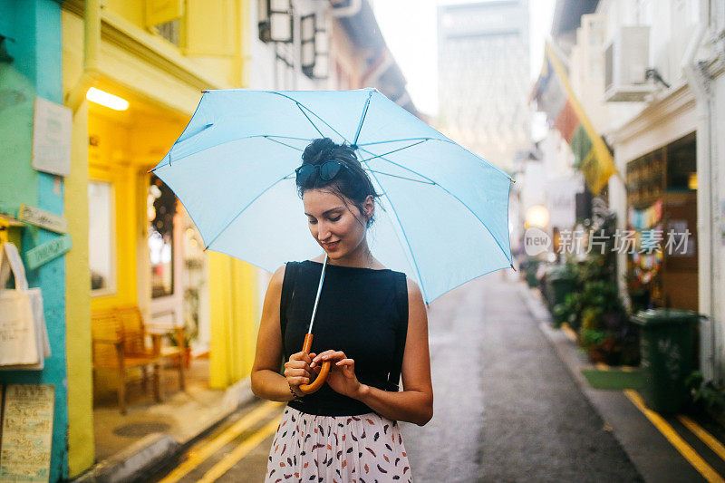 旅女在雨中探索新加坡的小巷子