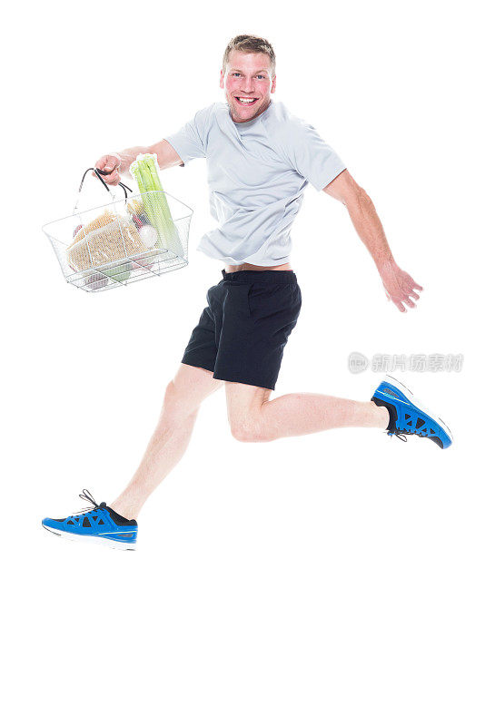帅哥提着购物篮，里面装着各种水果和蔬菜，跳来跳去