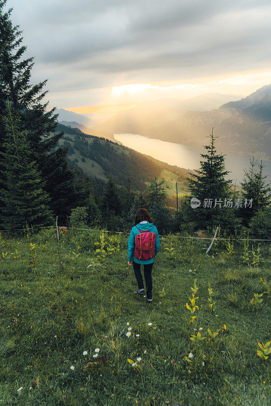 风景的女人看湖在瑞士阿尔卑斯山日落