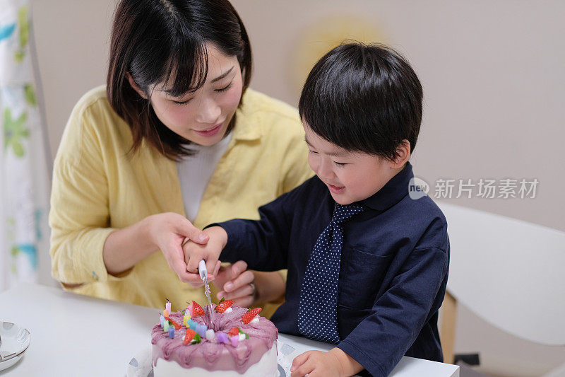 孩子和妈妈一起切生日蛋糕