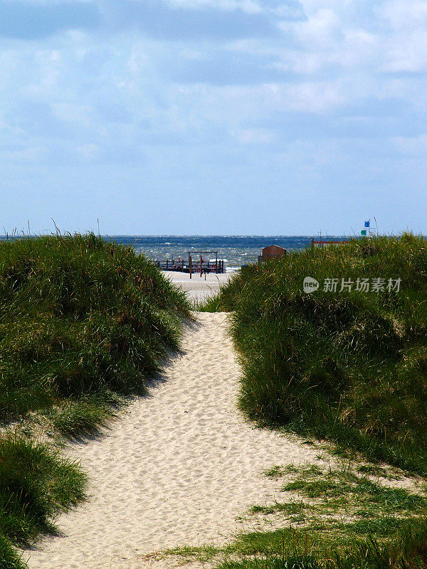 一路走到沙滩上的沙丘，阳光灿烂的一天