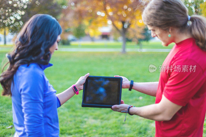 千禧一代的年轻人在公园里用科技观看iPad视频