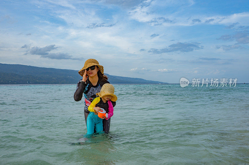 母亲和女儿在海边玩耍