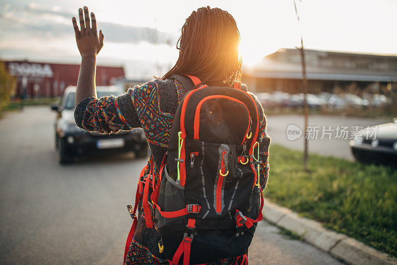 黑人背包女在街上挥手