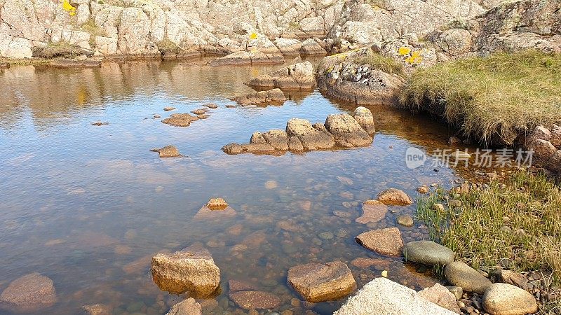 悬崖上的岩石和岩石池由红彼得黑德花岗岩制成