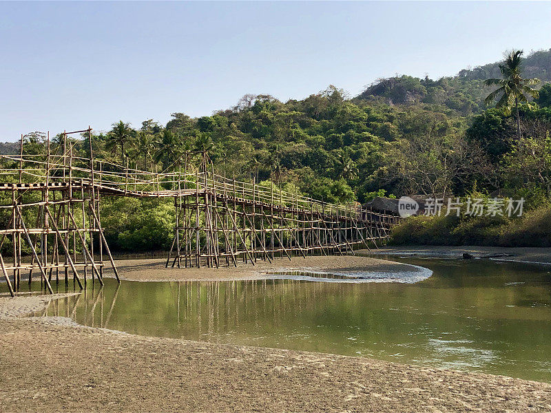 热带海滩岩石池泻湖椰子树，岩石，竹桥和金色的沙像天堂般的海滩度假照片，假日在果阿度假，Palolem海滩，南印度，海岸街道，天然岩石反射水面涟漪