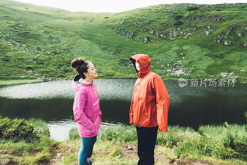年轻夫妇在美丽的湖附近的山上玩耍