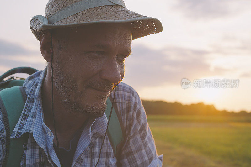 成年男子冒险家徒步在美丽的夏日日落大自然