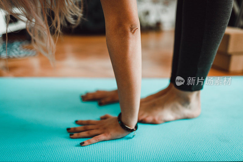 女人在家里做瑜伽，摸脚趾头