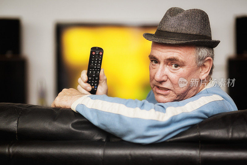 一位老人看电视时遥控器有问题
