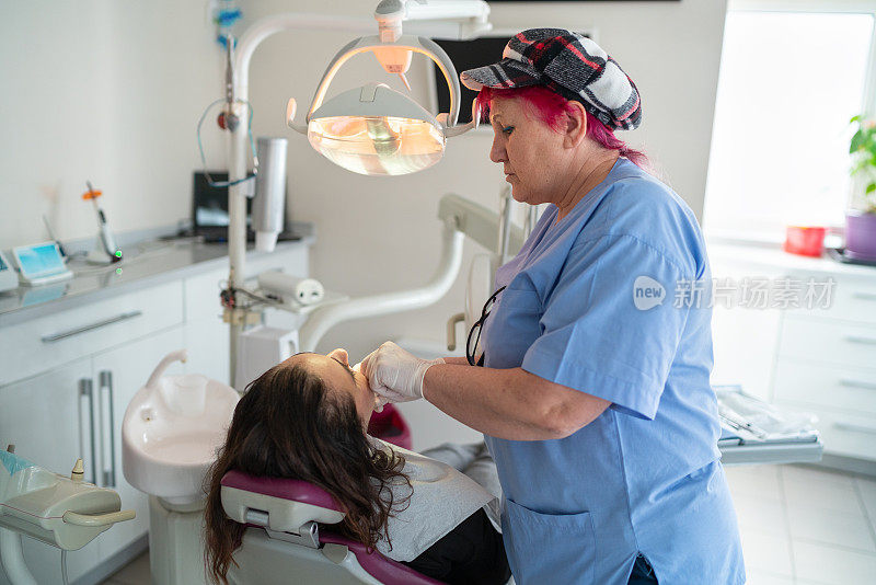 女牙医在她的办公室治疗女性病人