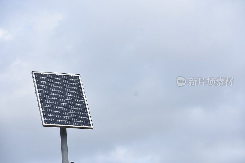 在多云的天空下，一块太阳能电池板