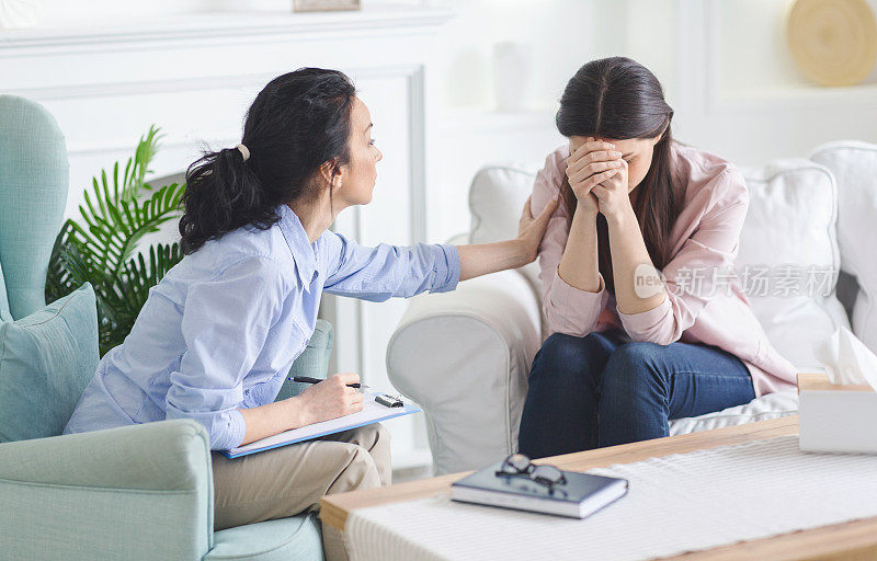一个伤心的年轻女人在心理咨询时哭泣，分享她的问题