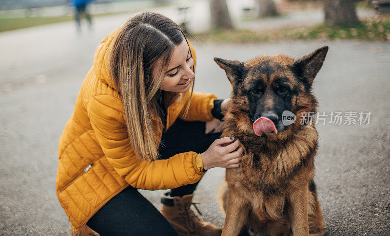 年轻女子和德国牧羊犬在公园里玩