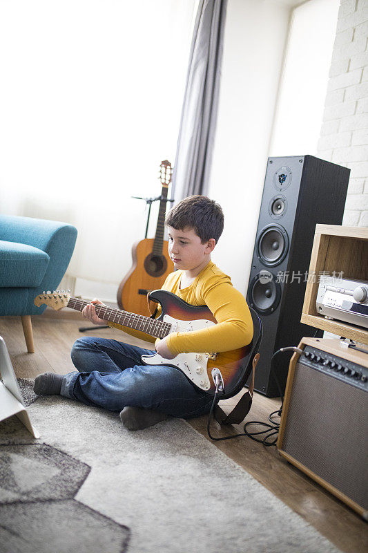 小男孩在客厅里弹电吉他