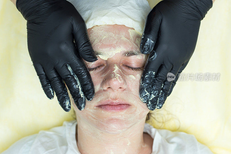 美容师用手按摩女性脸上的皮肤。