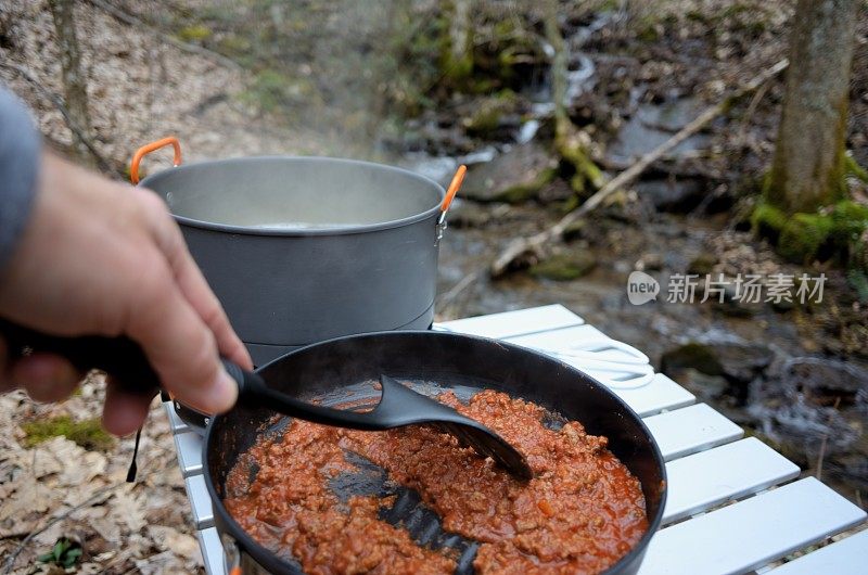 在小溪边用野营炉煮意大利面