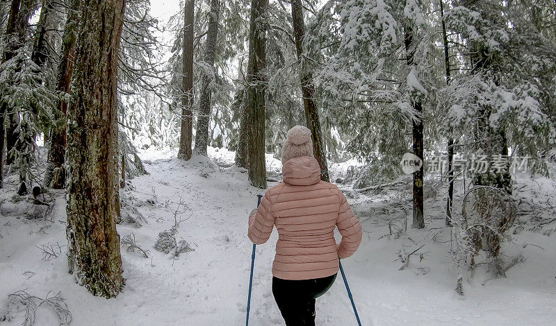 女性徒步旅行者沿着雪道行走