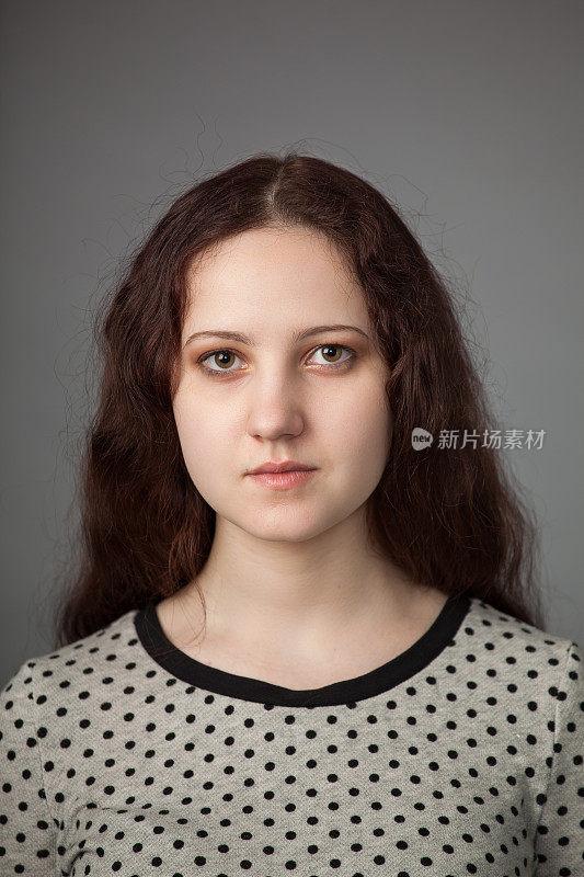 一个留着棕色长发的19岁女人的工作室肖像