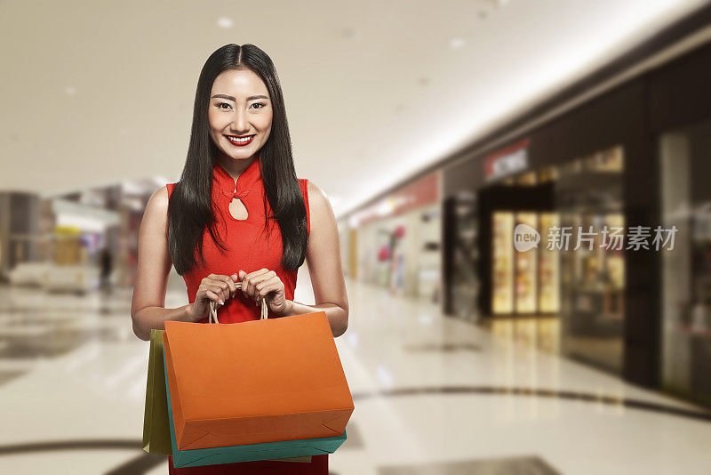 穿着旗袍拿着购物袋的中国妇女