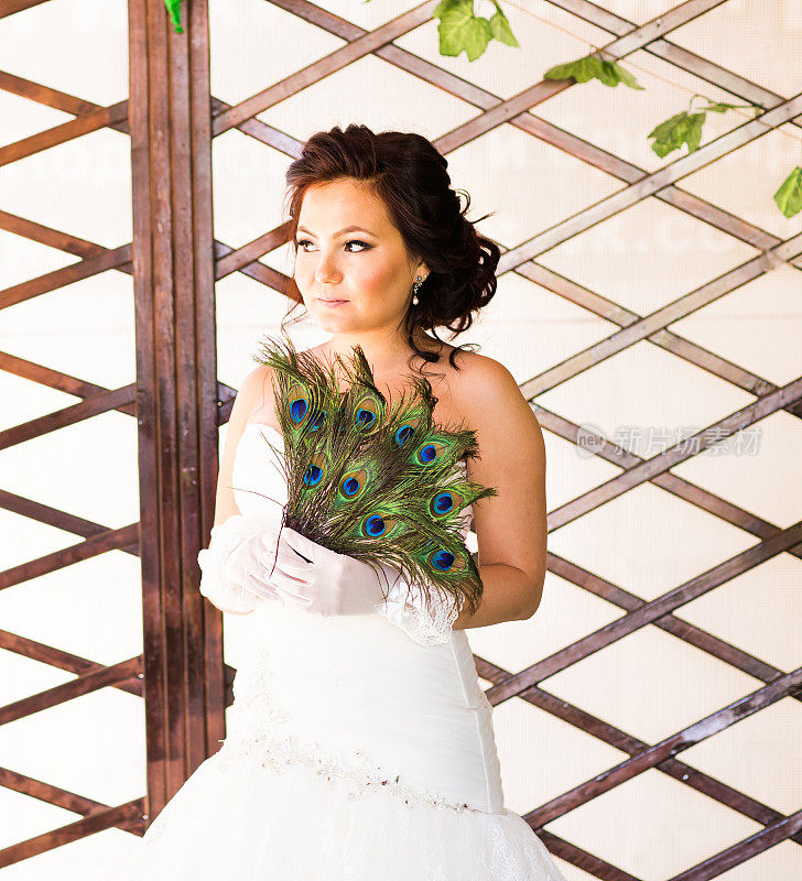 新娘用孔雀羽毛做的扇子靠近