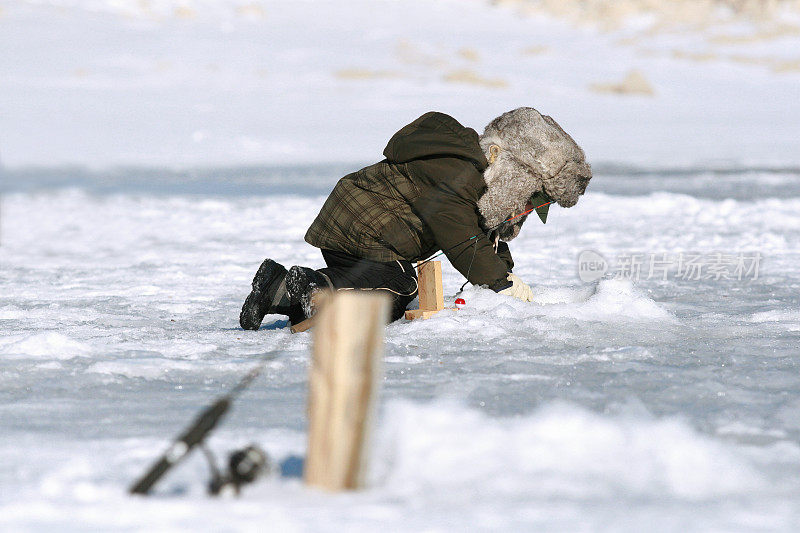 男孩冰上钓鱼