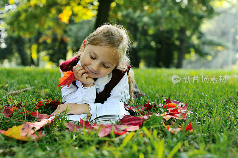 小女生躺在公园里看书