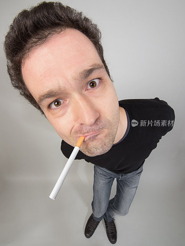 灰色背景下吸烟男子的高角度肖像